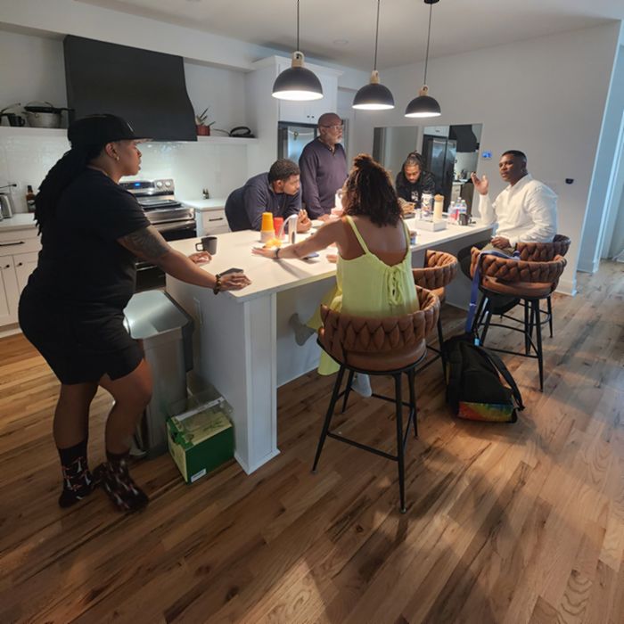 Community members gathered in conversation around a kitchen island.