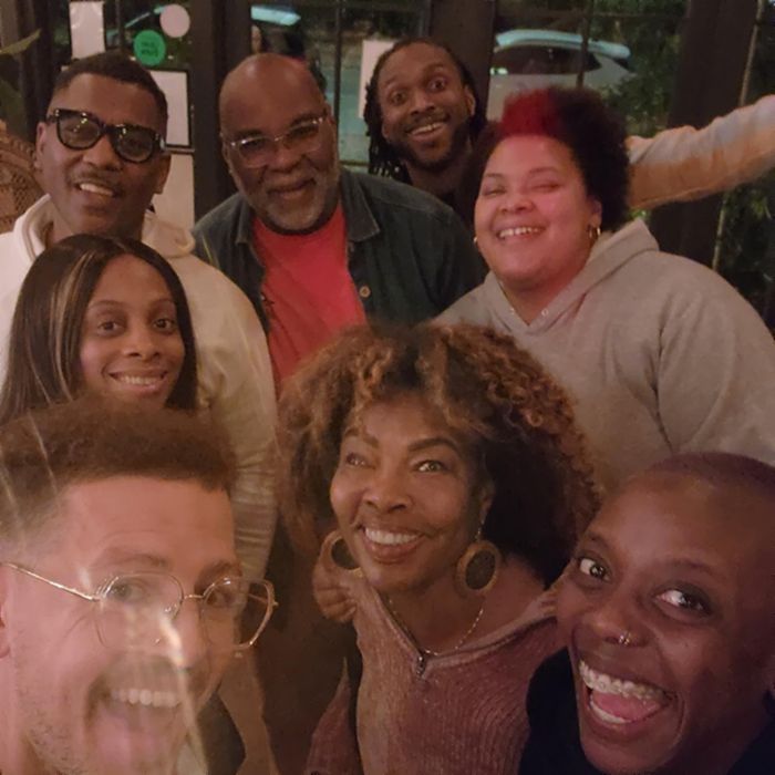 Eight community members crowded together, laughing, for a group photo.