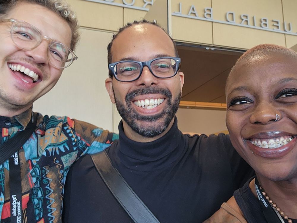 Julian, a colleague, and Imani grinning together in a selfie at the Psychedelic Science conference.